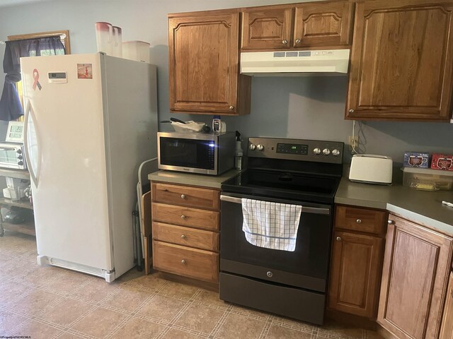 36 3rd St, Durbin, WV 26264 - kitchen with freestanding refrigerator, under cabinet range hood, stainless steel microwave, range with electric stovetop, and brown cabinets