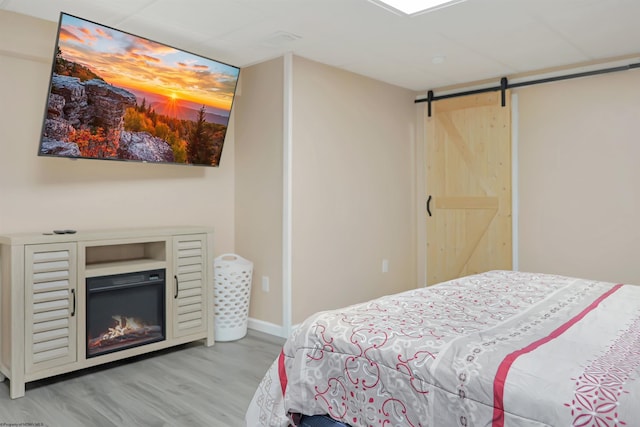 16 Cardinal Ln, Terra Alta, WV 26764 - bedroom with light wood-style flooring, a barn door, and baseboards