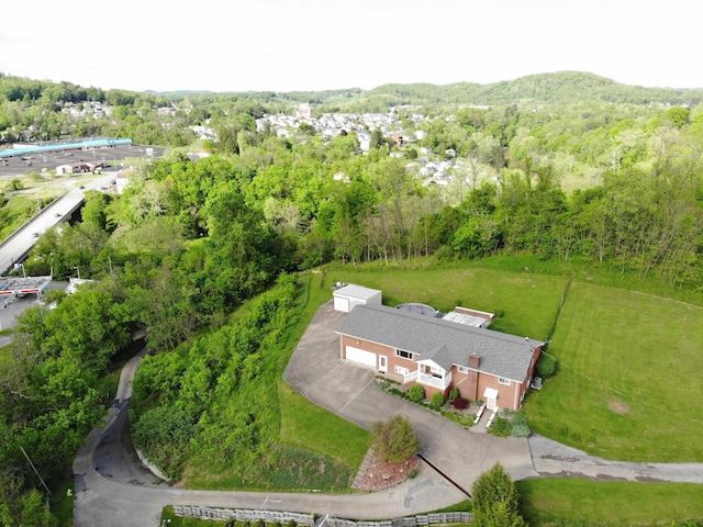 aerial view of property and surrounding area featuring a heavily wooded area