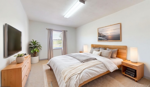 bedroom with light carpet and baseboards