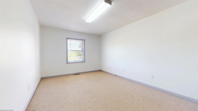 empty room with carpet and baseboards