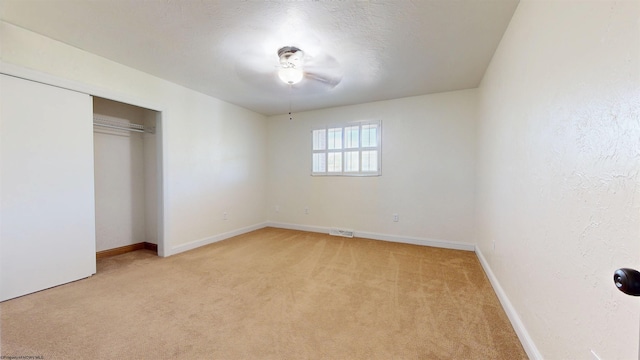 unfurnished bedroom featuring light colored carpet, baseboards, and a closet