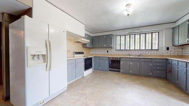 kitchen featuring white appliances, gray cabinets, a sink, and backsplash