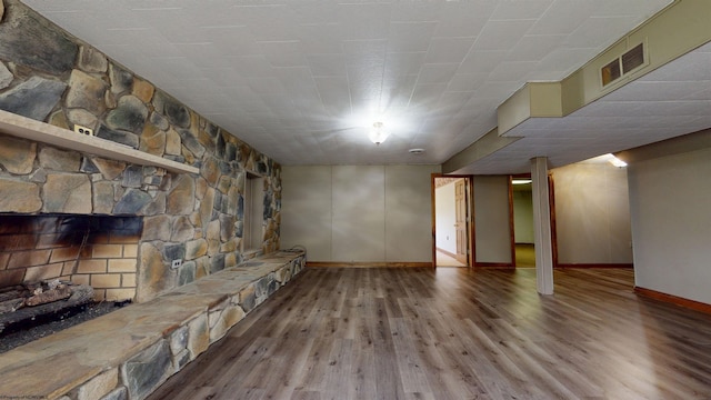 unfurnished living room featuring wood finished floors, baseboards, and a fireplace