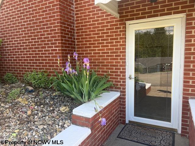 doorway to property with brick siding