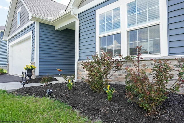 view of home's exterior with roof with shingles and an attached garage