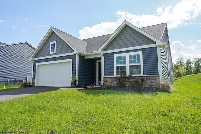craftsman house with stone siding, driveway, a front yard, a shingled roof, and a garage