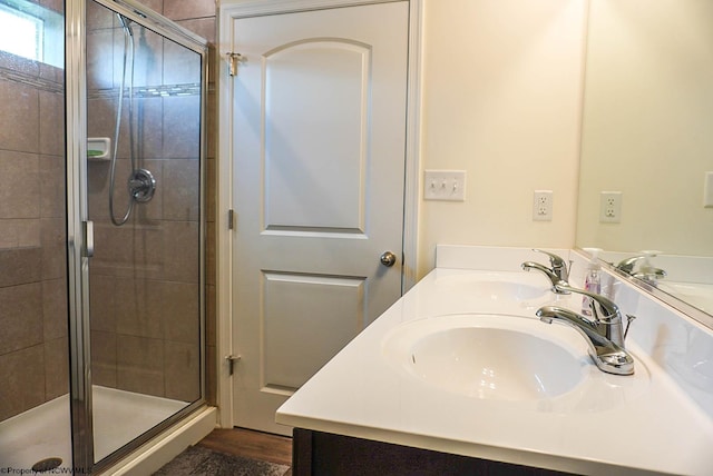 bathroom with a shower stall and double vanity