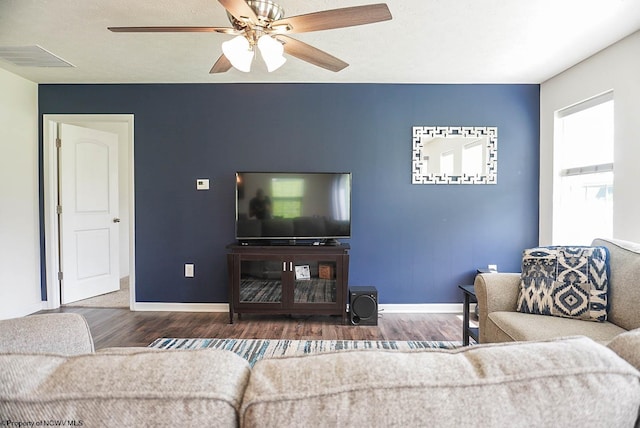 living area with wood finished floors, baseboards, and ceiling fan