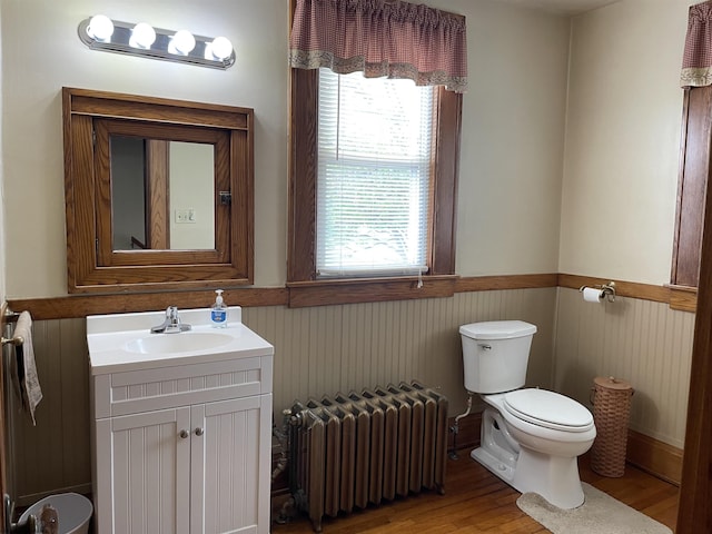 155 E St, Masontown, WV 26542 - half bathroom with radiator heating unit, toilet, wood finished floors, and vanity