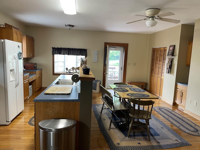 155 E St, Masontown, WV 26542 - kitchen featuring white fridge with ice dispenser, a sink, ceiling fan, light wood-style floors, and a kitchen island with sink
