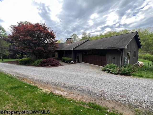 677 Dylan Rd, Elkins, WV 26241 - view of front of home featuring a garage, gravel driveway, and a chimney