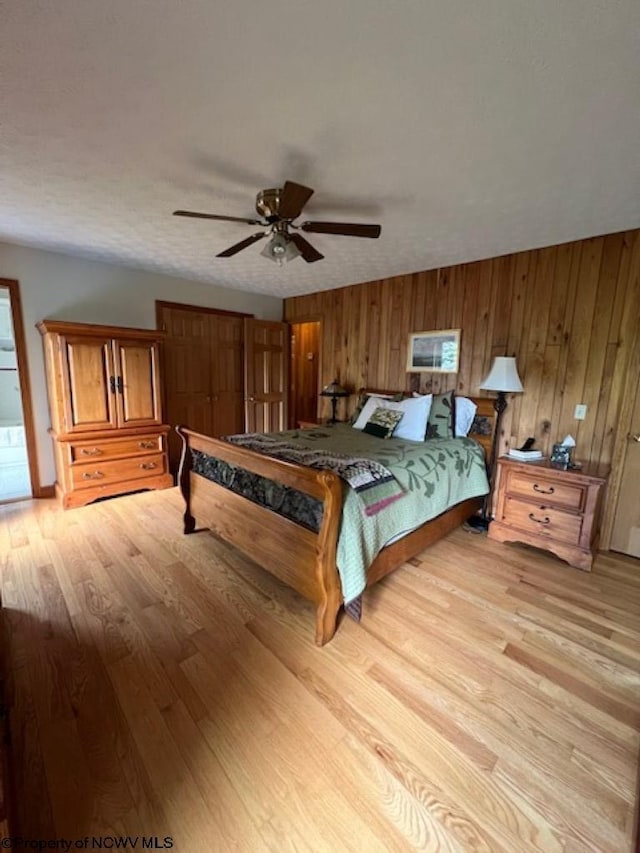 677 Dylan Rd, Elkins, WV 26241 - bedroom featuring light wood-style floors, wooden walls, and ceiling fan