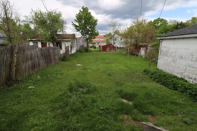 view of yard featuring a storage shed and an outbuilding