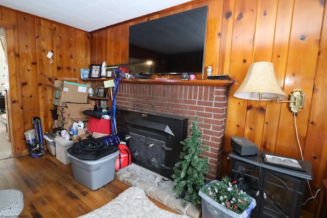 living area featuring wood finished floors, a fireplace, and wood walls