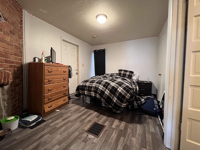 445 Baird St Unit 4, Morgantown, WV 26505 - bedroom featuring dark wood finished floors, a textured ceiling, and brick wall