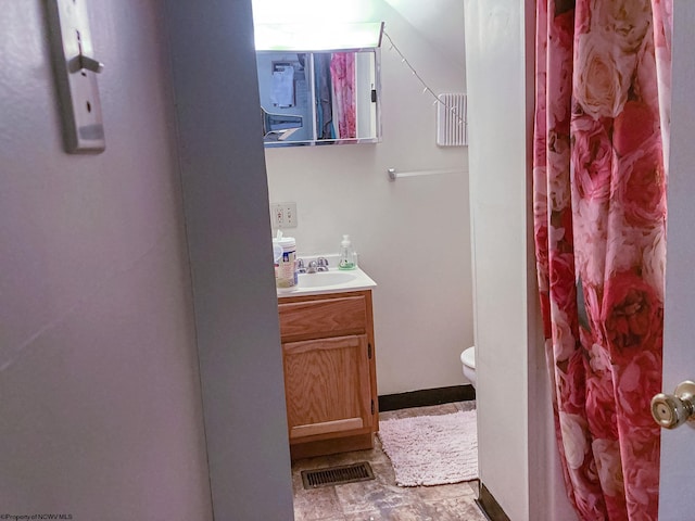 bathroom with toilet, vanity, and a shower with shower curtain
