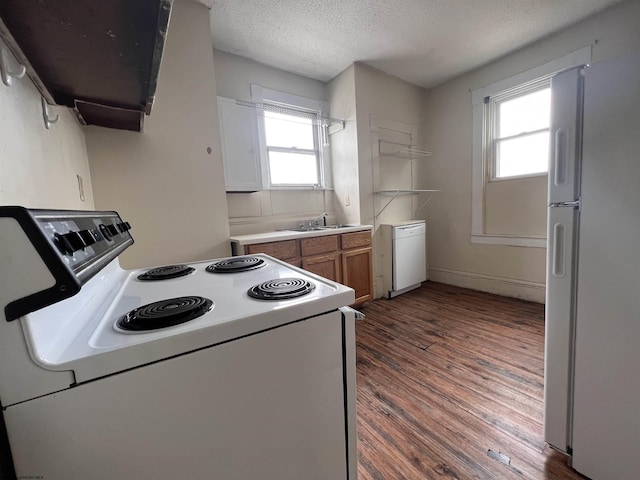 kitchen with white appliances, brown cabinetry, dark wood-type flooring, a textured ceiling, and range hood