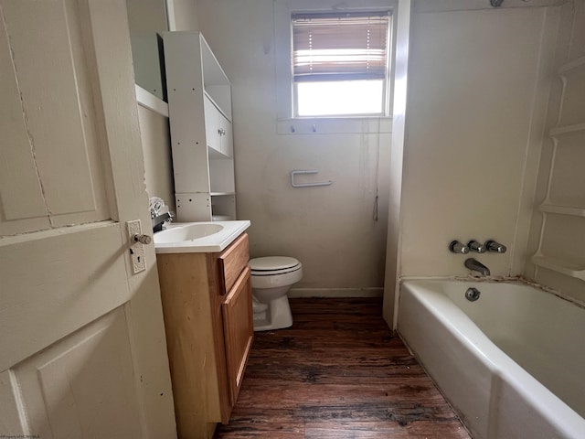 bathroom with vanity, toilet, wood finished floors, and shower / bathtub combination