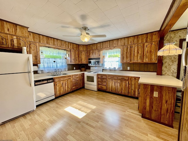 303 Morgantown St, Kingwood, WV 26537 - kitchen featuring white appliances, a sink, brown cabinets, light countertops, and wallpapered walls