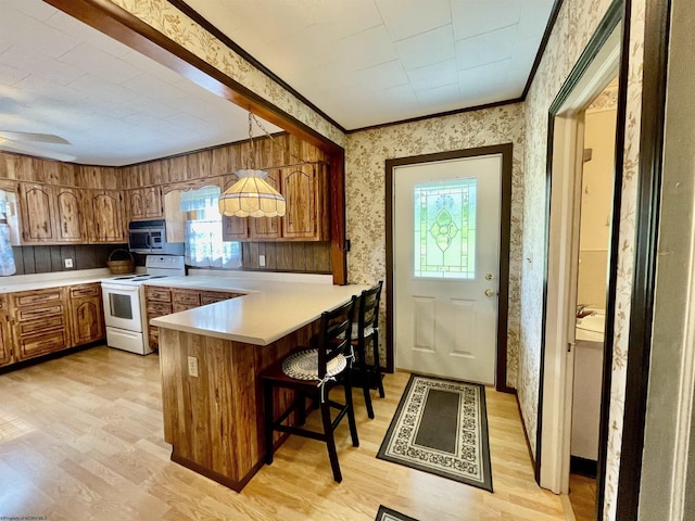 303 Morgantown St, Kingwood, WV 26537 - kitchen with electric stove, a peninsula, light wood-style flooring, brown cabinets, and light countertops