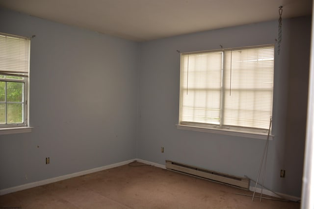 carpeted spare room with baseboard heating and baseboards
