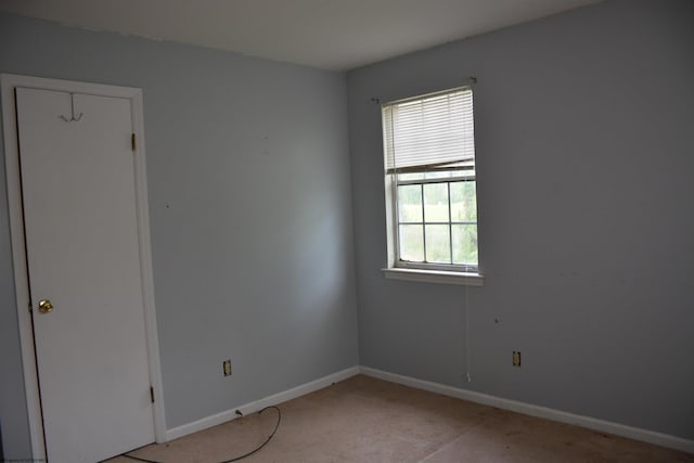 unfurnished room with light carpet and baseboards