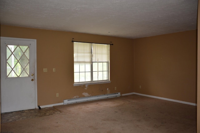 carpeted empty room featuring a baseboard heating unit, a textured ceiling, and baseboards
