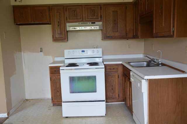 kitchen with white appliances, under cabinet range hood, light flooring, and light countertops