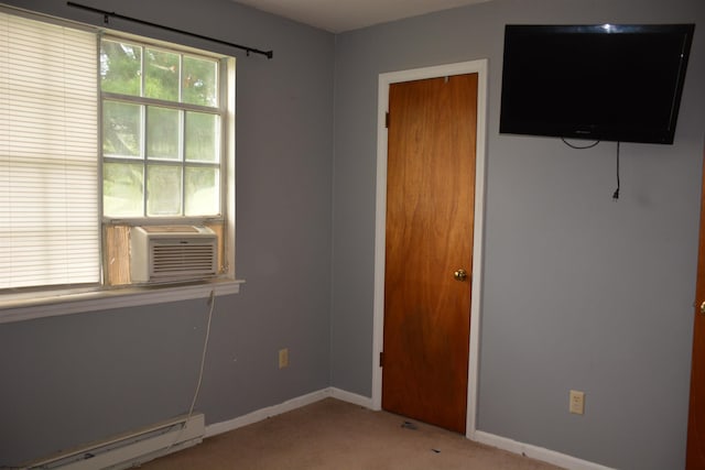 unfurnished bedroom with a baseboard radiator, light colored carpet, cooling unit, and baseboards