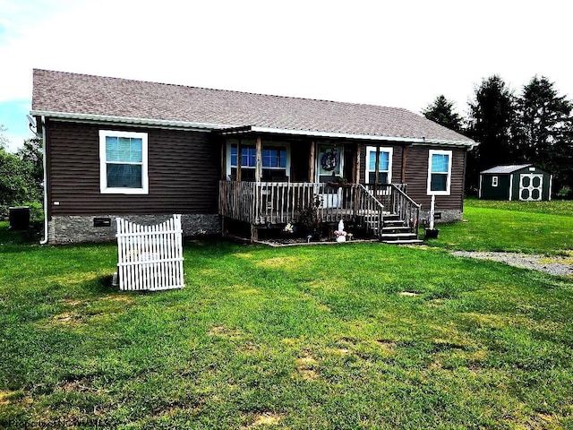 view of front of home featuring crawl space, a storage unit, an outdoor structure, a front yard, and covered porch