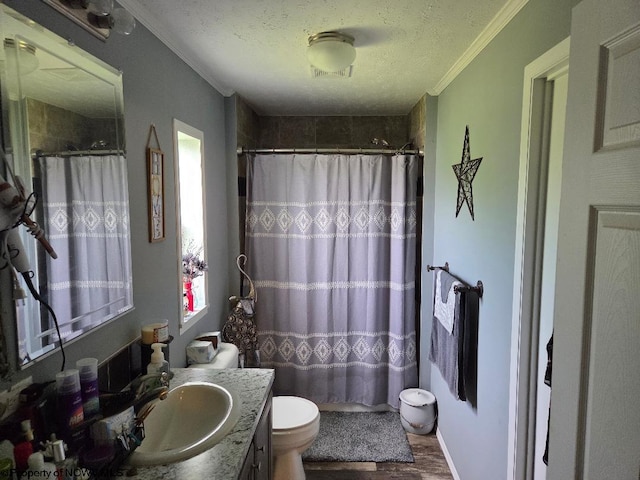 bathroom with wood finished floors, crown molding, vanity, a textured ceiling, and toilet