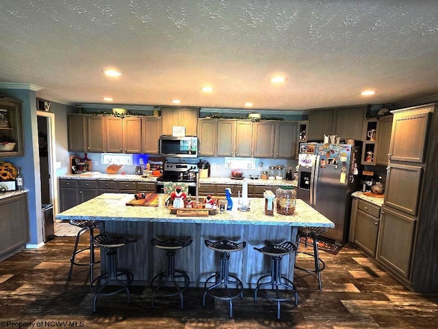 kitchen featuring stainless steel appliances, open shelves, a kitchen breakfast bar, a kitchen island with sink, and recessed lighting