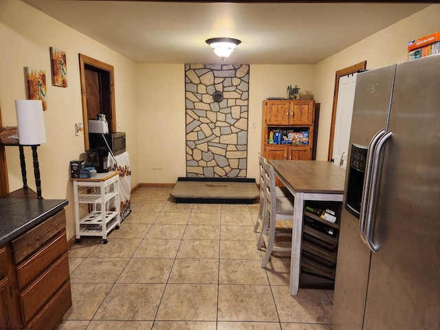 784 Ona St, Grafton, WV 26354 - kitchen featuring appliances with stainless steel finishes, dark countertops, light tile patterned floors, brown cabinets, and baseboards