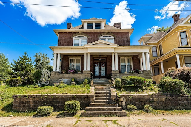 traditional style home featuring a chimney, brick siding, and a porch