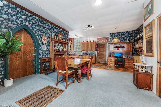 dining area with wallpapered walls, carpet, arched walkways, and a paneled ceiling