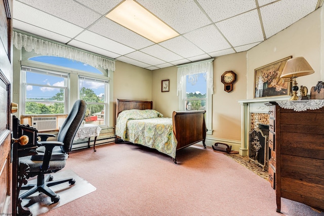 carpeted bedroom with a paneled ceiling, baseboard heating, cooling unit, and a fireplace with flush hearth