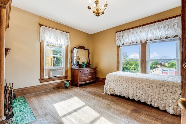 bedroom featuring wood-type flooring, multiple windows, cooling unit, and baseboards
