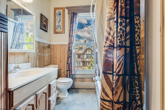 bathroom with a wainscoted wall, wood walls, vanity, and toilet