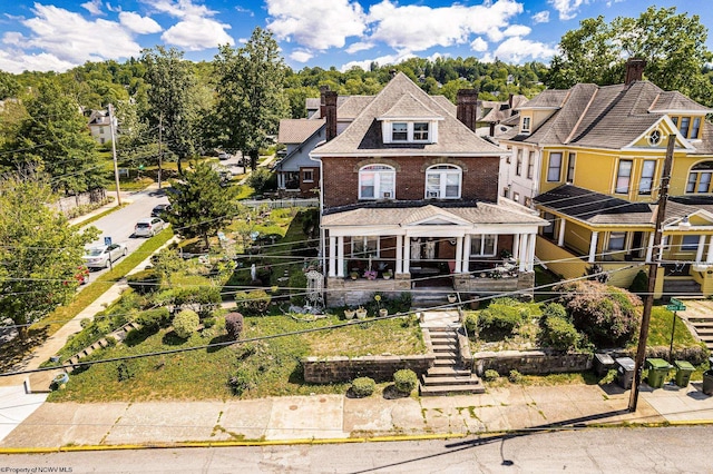 view of front of property with stairway, a chimney, and brick siding