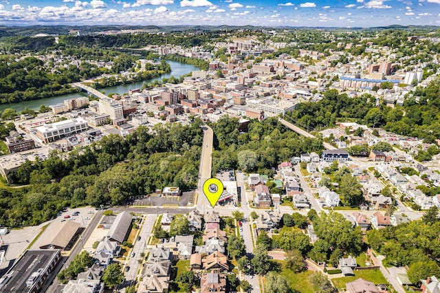 aerial overview of property's location with a nearby body of water and a tree filled landscape