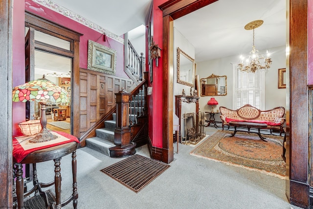 interior space featuring carpet floors, a chandelier, stairs, and a baseboard heating unit