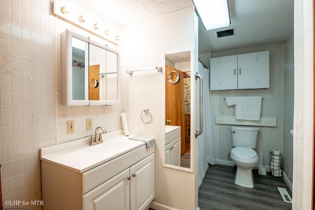 22 N Euclid Ave, Thomas, WV 26292 - bathroom with wood finished floors, vanity, tile walls, a textured ceiling, and toilet