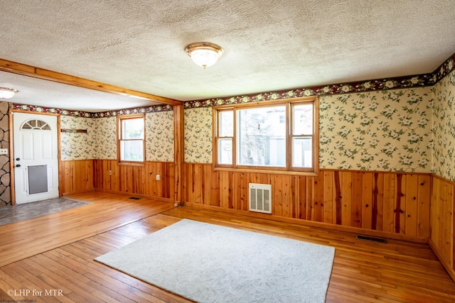 22 N Euclid Ave, Thomas, WV 26292 - unfurnished room with hardwood / wood-style floors, a textured ceiling, wainscoting, wallpapered walls, and wood walls