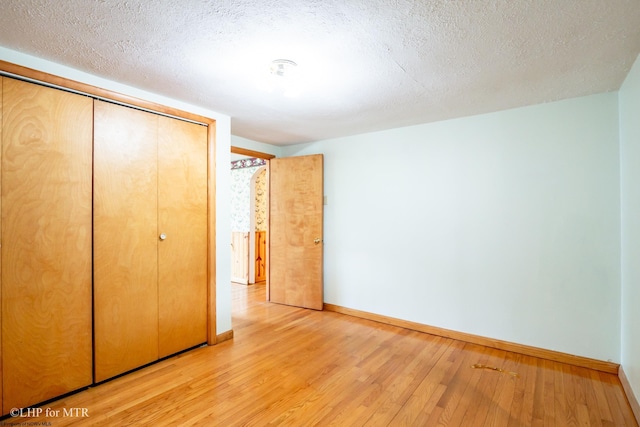 22 N Euclid Ave, Thomas, WV 26292 - unfurnished bedroom with baseboards, light wood-style flooring, a textured ceiling, and a closet