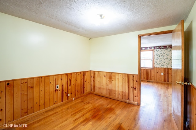 22 N Euclid Ave, Thomas, WV 26292 - spare room with a wainscoted wall, wood finished floors, wood walls, and a textured ceiling