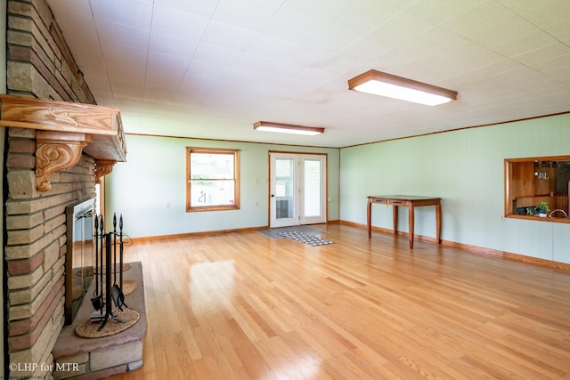 22 N Euclid Ave, Thomas, WV 26292 - unfurnished living room featuring light wood-type flooring, a brick fireplace, and baseboards
