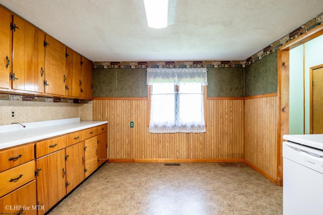 22 N Euclid Ave, Thomas, WV 26292 - kitchen with white dishwasher, a wainscoted wall, light countertops, light flooring, and brown cabinets