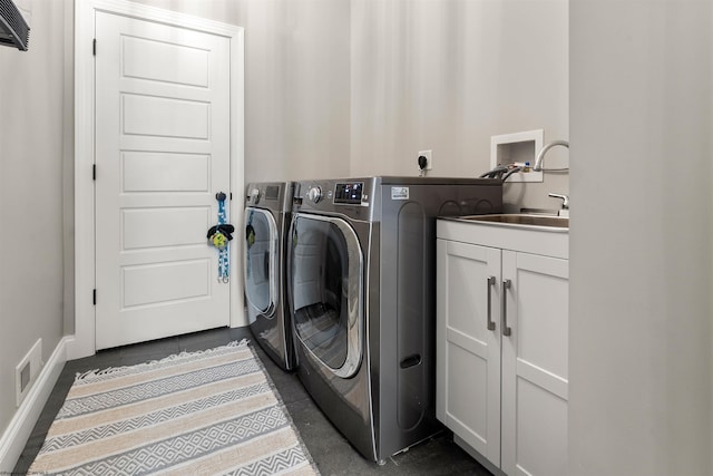 washroom featuring cabinet space, washing machine and dryer, and baseboards
