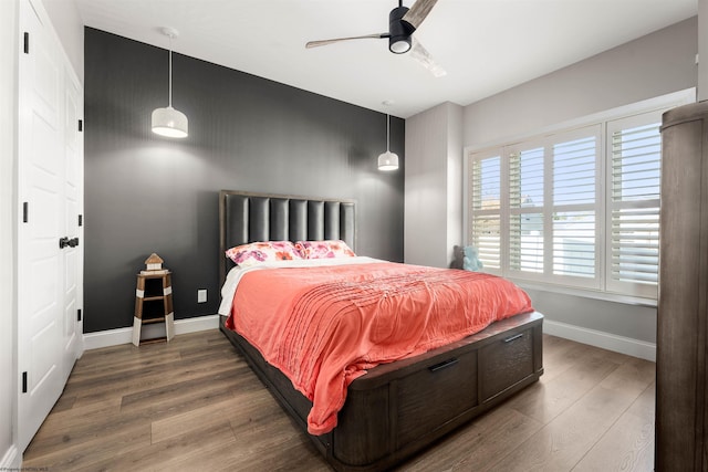 bedroom featuring wood finished floors, baseboards, and ceiling fan